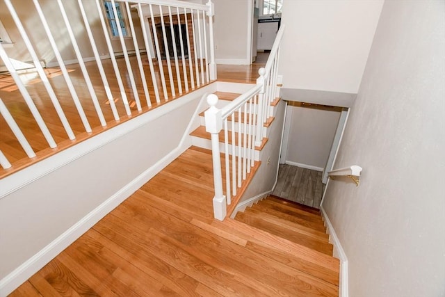 stairway featuring wood finished floors and baseboards