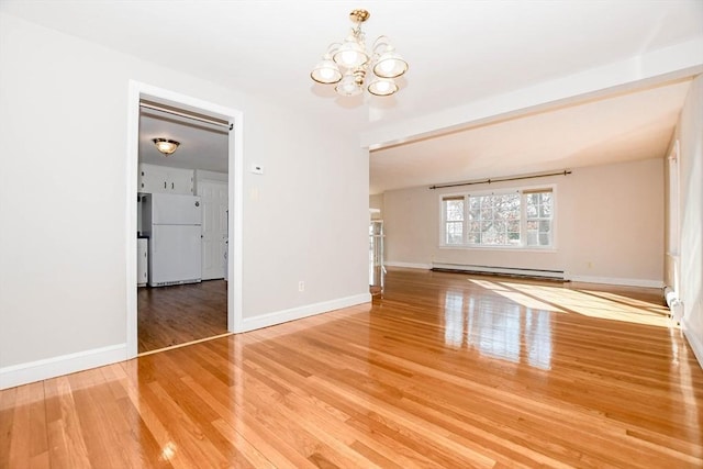 empty room featuring baseboards, a baseboard heating unit, an inviting chandelier, and wood finished floors