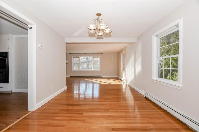 unfurnished dining area featuring an inviting chandelier, baseboards, light wood-type flooring, and baseboard heating