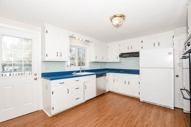 kitchen with light wood finished floors, under cabinet range hood, dishwasher, freestanding refrigerator, and a sink