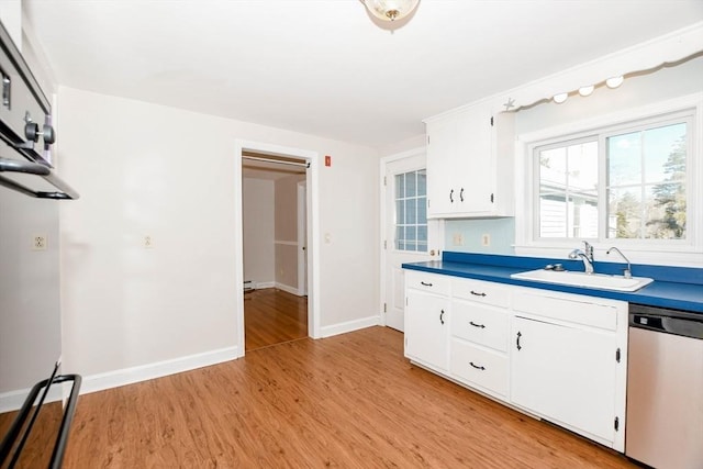 kitchen with light wood finished floors, baseboards, stainless steel dishwasher, white cabinets, and a sink