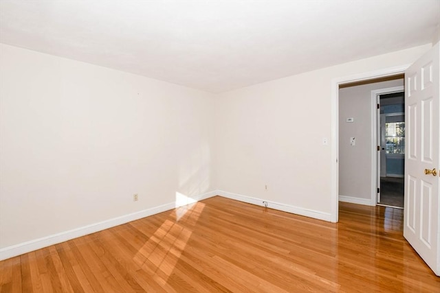 unfurnished room featuring baseboards and light wood finished floors