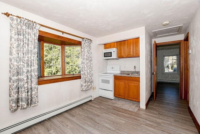 kitchen with white appliances, a baseboard radiator, a sink, light countertops, and light wood-style floors