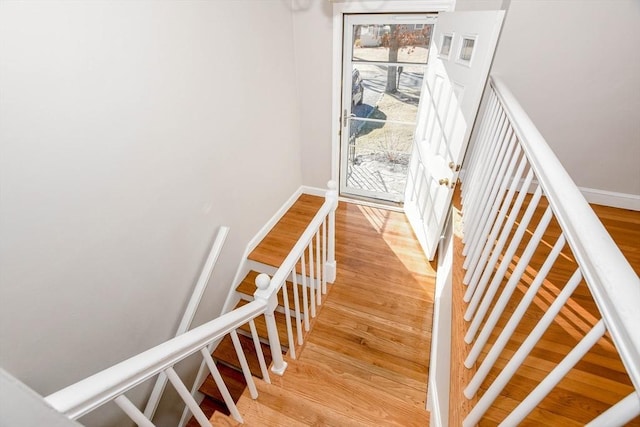 staircase with baseboards and wood finished floors