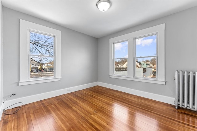 unfurnished room with hardwood / wood-style flooring and radiator