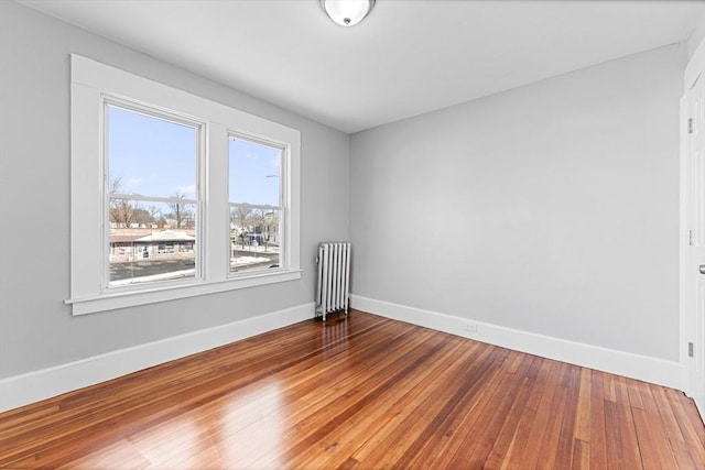 empty room featuring radiator and wood-type flooring