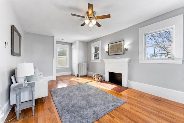 living room with ceiling fan, radiator heating unit, and wood-type flooring