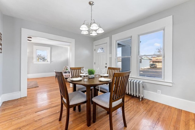 dining room with an inviting chandelier, radiator, light hardwood / wood-style floors, and a wealth of natural light