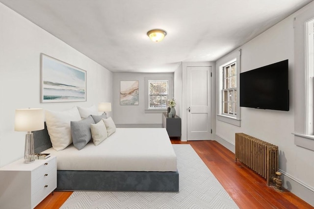 bedroom with hardwood / wood-style flooring and radiator heating unit