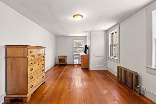 unfurnished bedroom featuring dark hardwood / wood-style floors and radiator heating unit