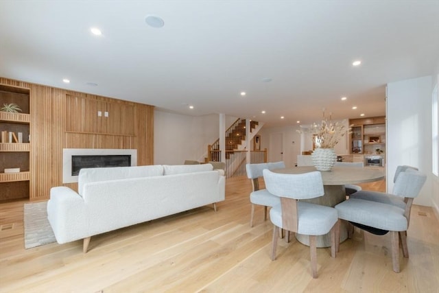 dining space with a large fireplace and light wood-type flooring