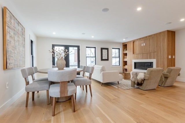 dining space featuring light hardwood / wood-style flooring and a fireplace