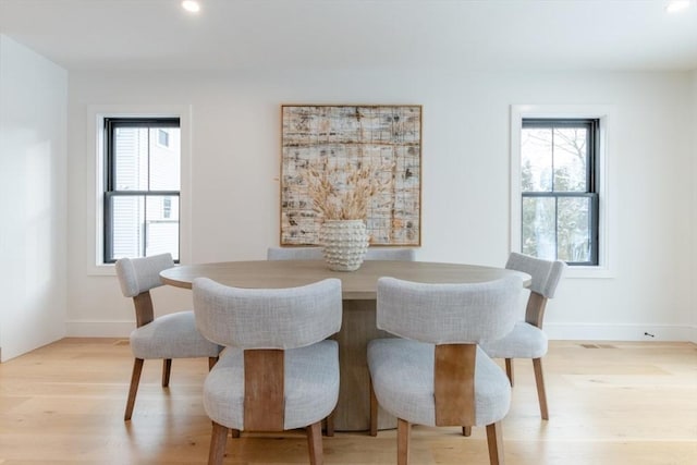 dining space with a healthy amount of sunlight and light hardwood / wood-style floors