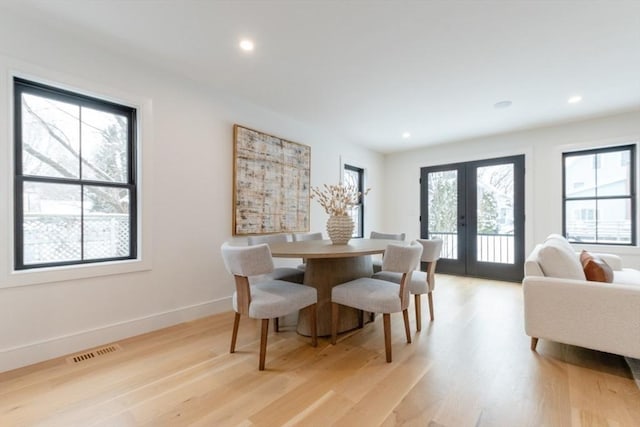 dining room with light wood-type flooring, french doors, and a wealth of natural light