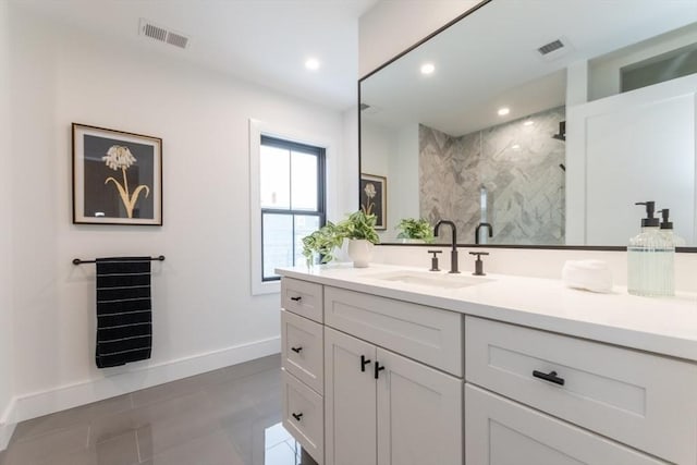 bathroom featuring tiled shower, tile patterned flooring, and vanity