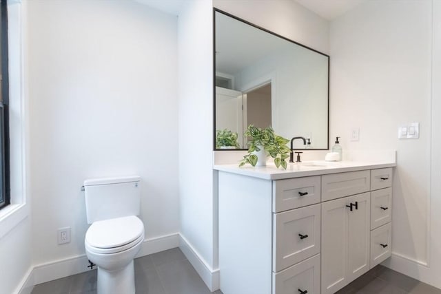 bathroom with vanity, toilet, and tile patterned floors