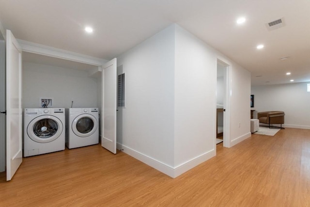 laundry room with light hardwood / wood-style flooring and independent washer and dryer