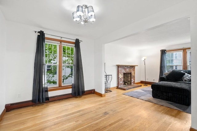 32 Saint Marks Rd Unit 1, Boston, MA 02124 - living area featuring light wood-style floors, a chandelier, baseboards, a brick fireplace, and a baseboard heating unit