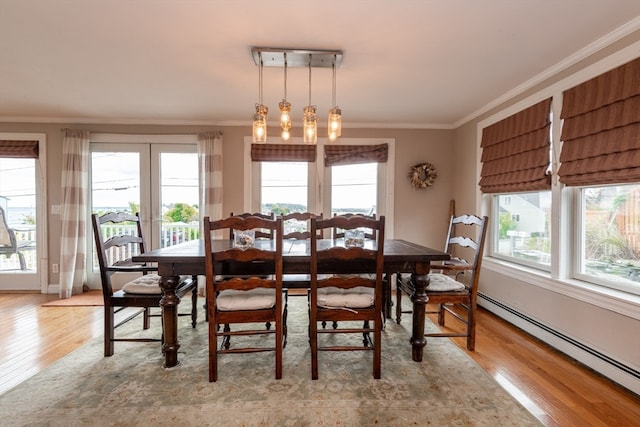 dining area with crown molding, french doors, light hardwood / wood-style flooring, and a baseboard heating unit