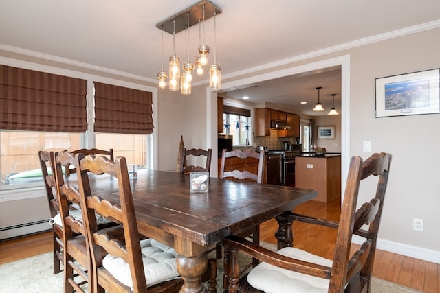 dining area featuring ornamental molding, a chandelier, and light hardwood / wood-style flooring