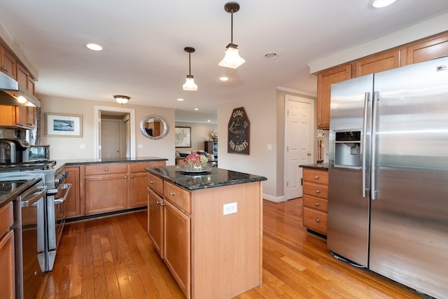 kitchen featuring pendant lighting, light hardwood / wood-style flooring, stainless steel appliances, and a center island