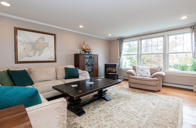 living room with ornamental molding, a wood stove, baseboard heating, and light hardwood / wood-style flooring