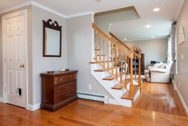 stairway featuring hardwood / wood-style flooring, ornamental molding, and baseboard heating