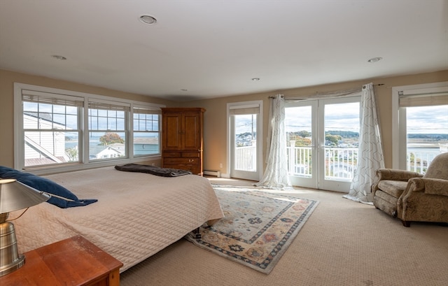 carpeted bedroom featuring a baseboard radiator, access to exterior, and multiple windows