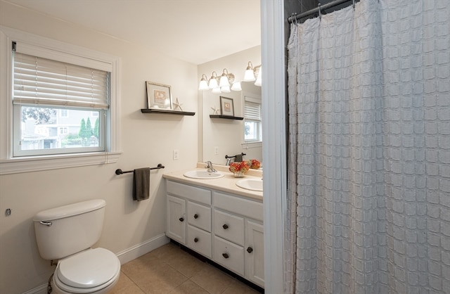 bathroom with tile patterned floors, toilet, vanity, and a wealth of natural light