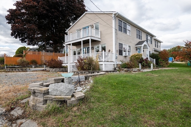 view of home's exterior featuring a balcony and a lawn