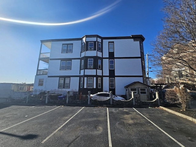 view of property featuring uncovered parking and fence