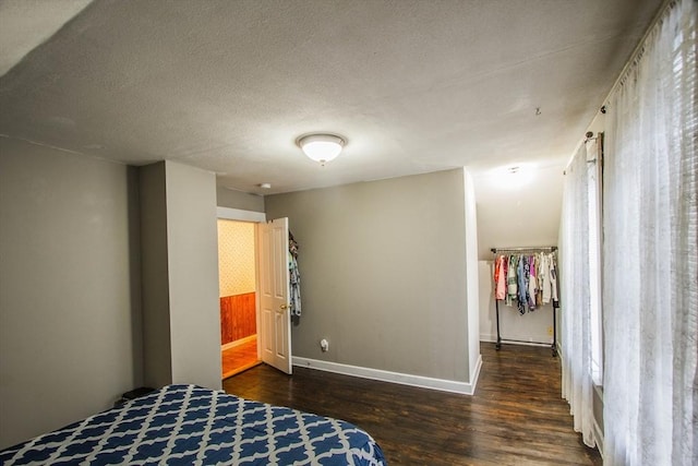 bedroom with dark hardwood / wood-style floors, a textured ceiling, and a closet