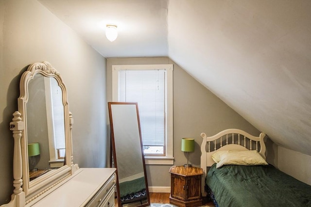 bedroom with vaulted ceiling and hardwood / wood-style flooring