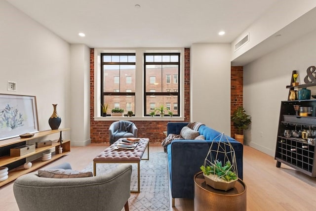 living room with light wood-type flooring and brick wall