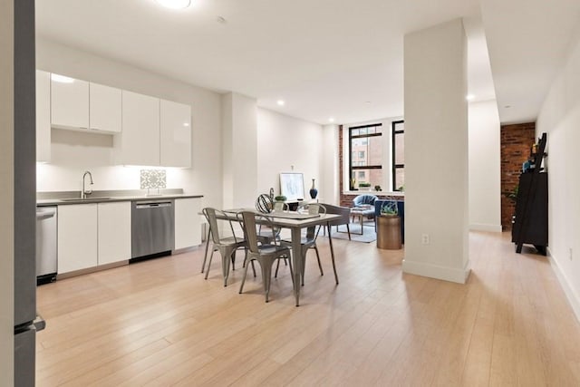 dining area with sink and light wood-type flooring