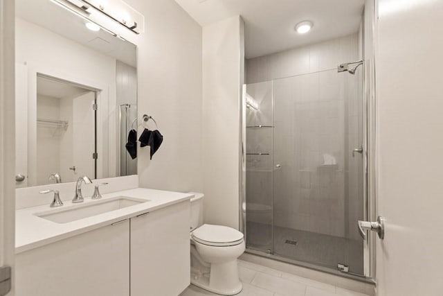 bathroom featuring tile patterned flooring, vanity, toilet, and a shower with shower door