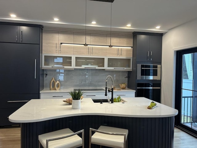 kitchen featuring a sink, a kitchen bar, and modern cabinets