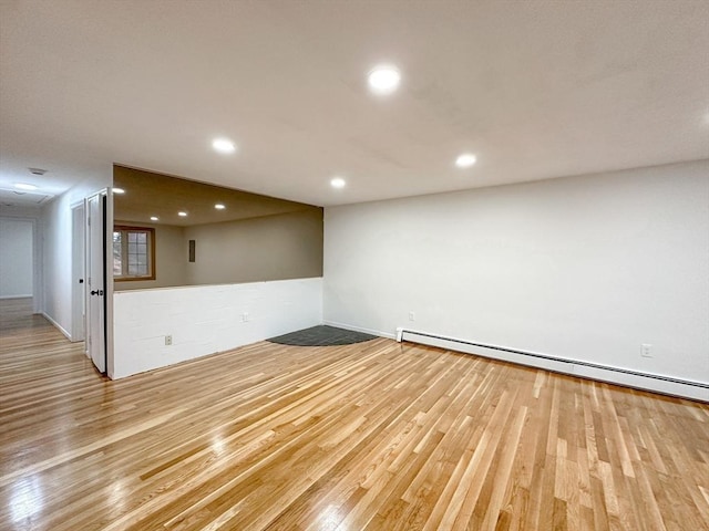 empty room with light hardwood / wood-style flooring and a baseboard radiator