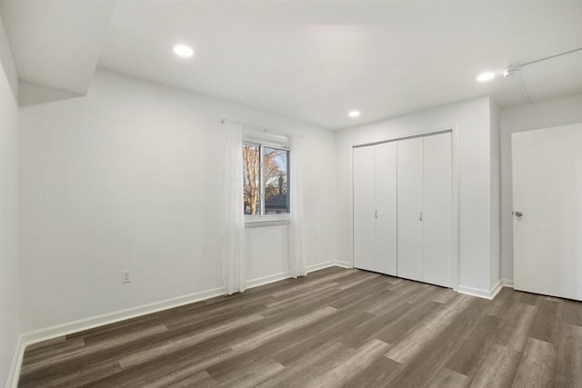 unfurnished bedroom with a closet and dark hardwood / wood-style flooring