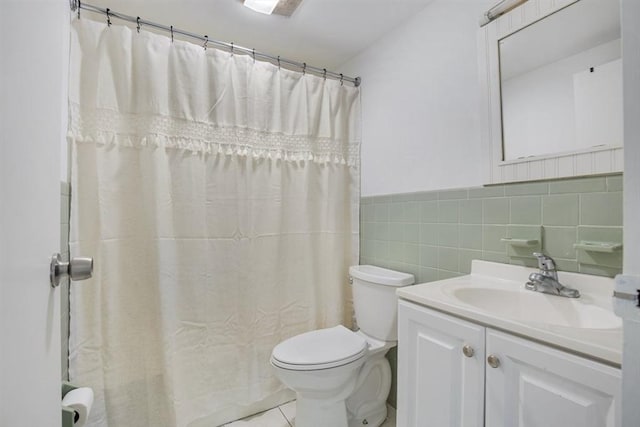 bathroom with toilet, tile walls, vanity, and curtained shower