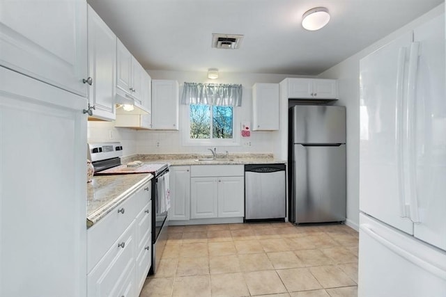 kitchen with light tile patterned floors, stainless steel appliances, backsplash, white cabinets, and sink