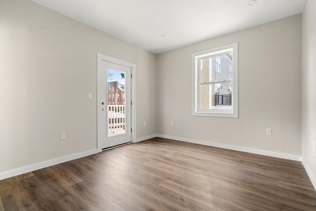 unfurnished room featuring baseboards and wood finished floors