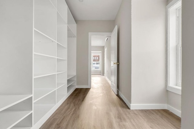 hall with baseboards and wood finished floors