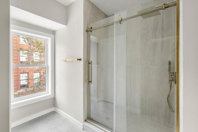 bathroom featuring baseboards, tile patterned flooring, and a shower stall