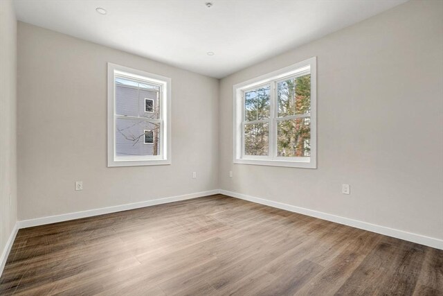 empty room featuring wood finished floors and baseboards