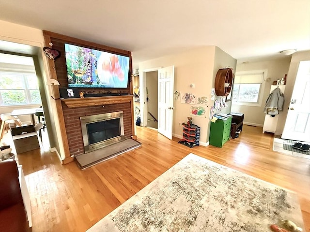 12 Cozy St Unit 12, Watertown, MA 02472 - living room with light wood-style floors, a brick fireplace, and healthy amount of natural light