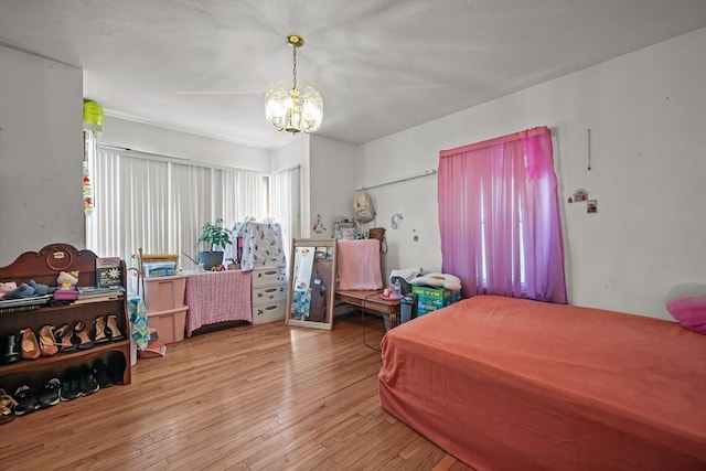 bedroom featuring a notable chandelier and hardwood / wood-style flooring