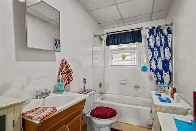 bathroom featuring a drop ceiling, toilet, vanity, and shower / bath combo