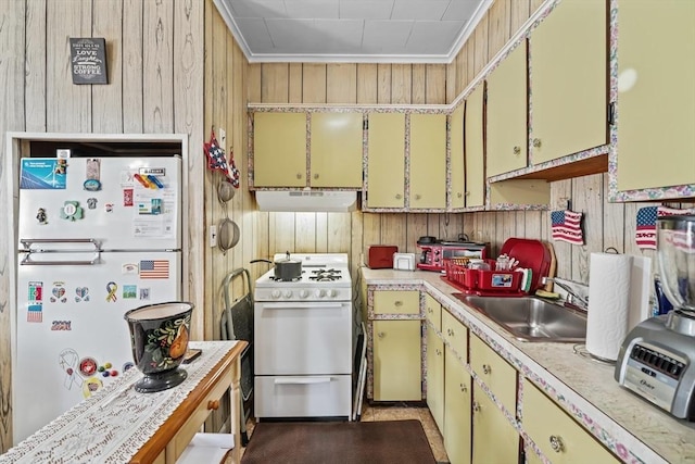 kitchen featuring a sink, yellow cabinets, white appliances, light countertops, and extractor fan