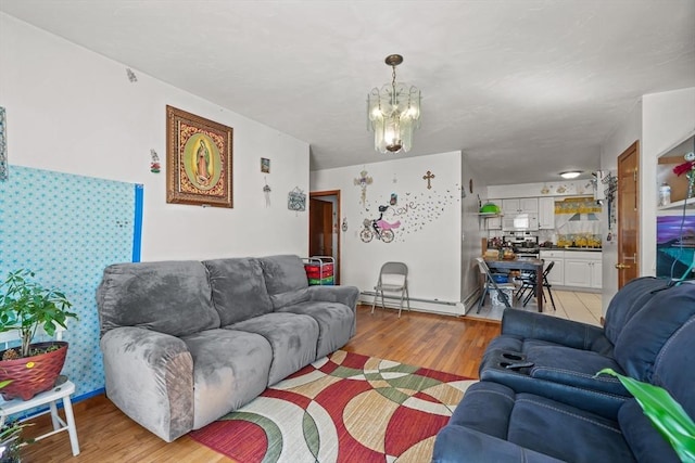 living room with a baseboard heating unit, a chandelier, and light wood finished floors